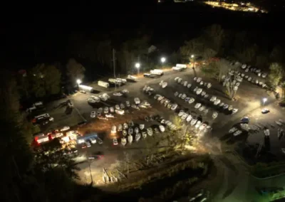 A parking lot filled with various boats, showcasing different sizes and colors, under Night time lighting Storage Lot Layout